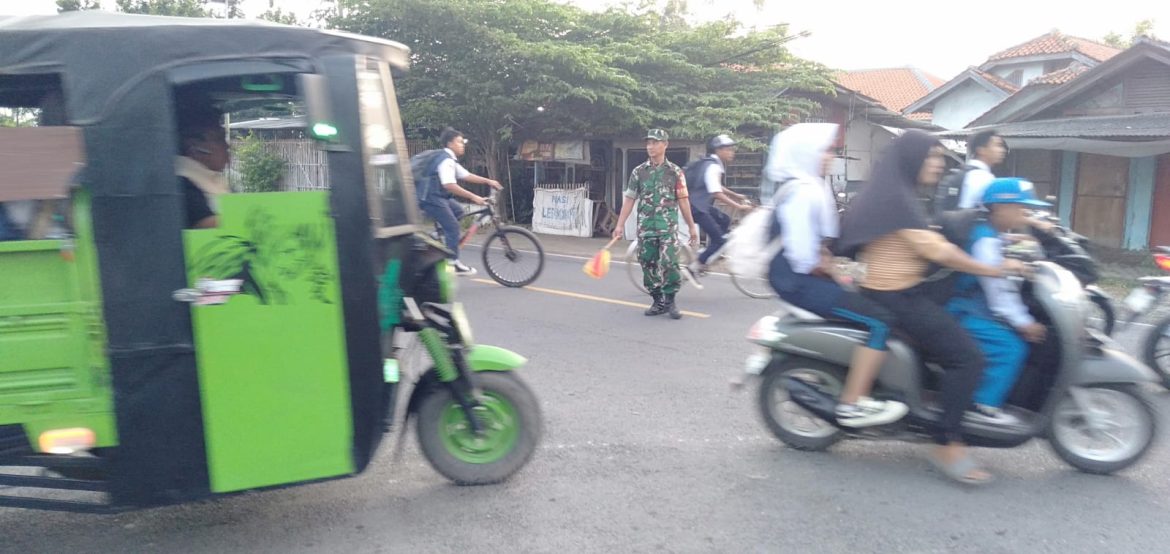 Babinsa Koramil 1609 Juntinyuat Indtamayu Lakukan Bantu Masyarakat dan Anak Sekolah Menyebrang Jalan Raya di Desa Juntikebon