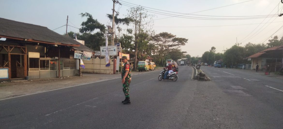 Tingkatkan Kepedulian Lingkungan, Babinsa Koramil 1605 Sukagumiwang Indramayu Bantu Masyarakat Menyebrangkan Jalan 