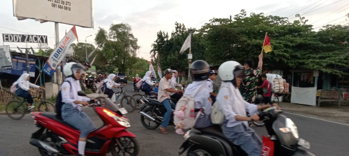 Anggota Koramil 1609 Juntinyuat Indramayu Membantu Masyarakat dan Anak Sekolah menyeberang Jalan Raya di Desa Juntikebon