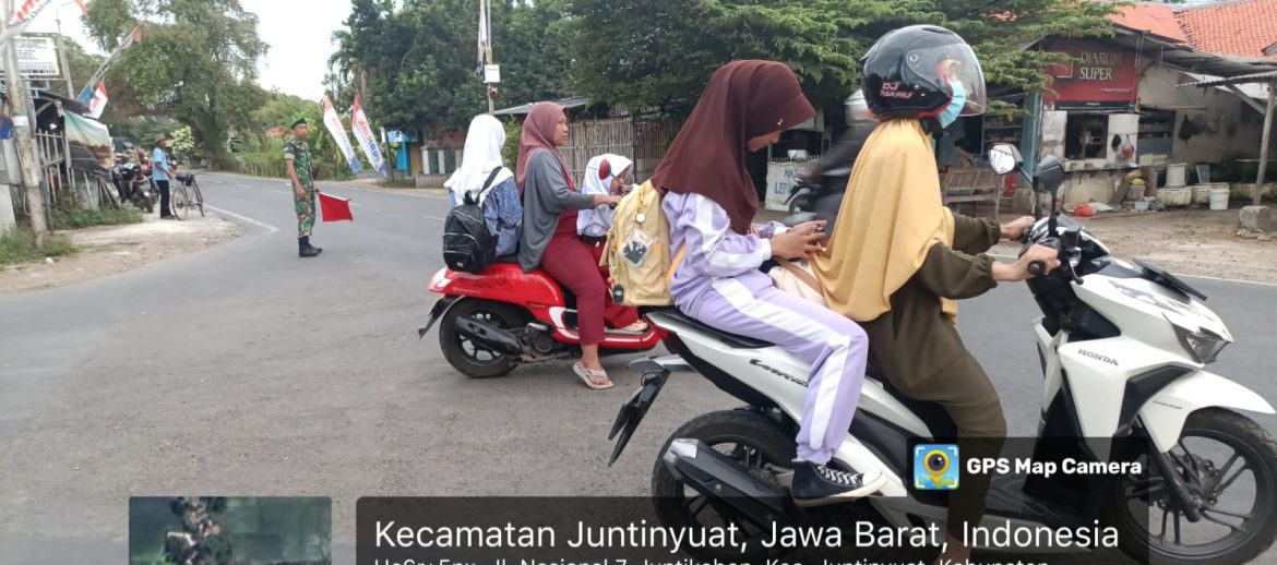 Anggota Koramil 1609 Juntinyuat Indramayu membantu Masyarakat dan Anak Sekolah menyeberang Jalan Raya Desa Juntikebon