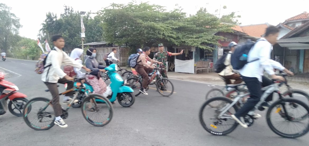 Babinsa Koramil 1609 Juntinyuat Indramayu Membantu Masyarakat dan Anak Sekolah menyeberang Jalan Raya Desa Juntikebon