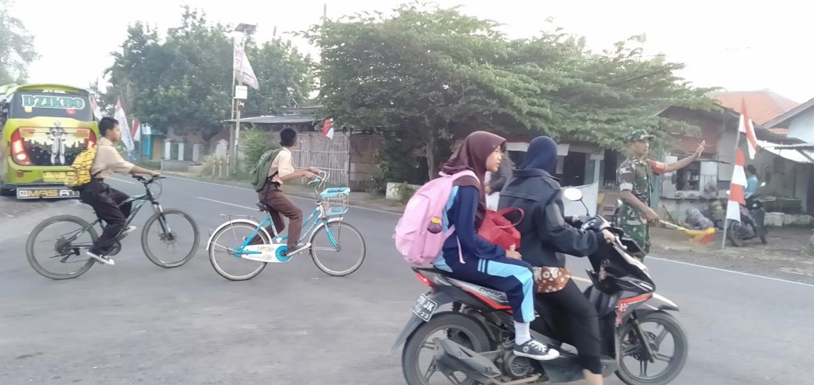 Anggota Koramil 1609 Juntinyuat Indramayu Membantu Masyarakat dan Anak Sekolah Untuk Menyebrang di Jalan Raya Desa Juntinyuat