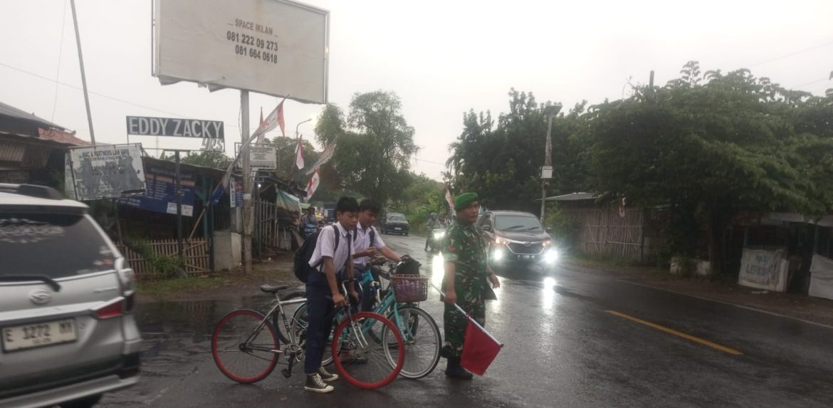 Anggota Koramil 1609 Juntinyuat Indramayu Bantu Masyarakat dan Anak Sekolah Menyebrang Jalan Raya di Desa Juntikebon