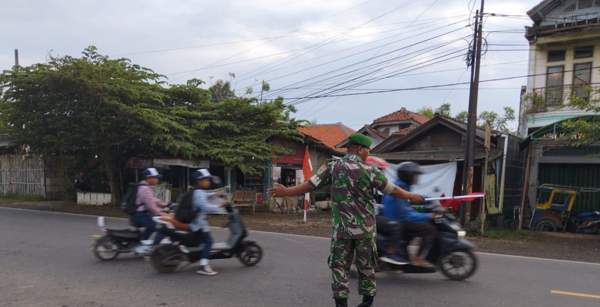 Babinsa Koramil 1609 Juntinyuat Indramayu Bantu Anak Sekolah dan Masyarakat Menyebrang Jalan Raya 