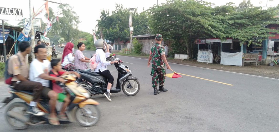 Anggota Koramil 1609 Juntinyuat Indramayu Membantu Masyarakat dan Anak Sekolah Untuk Menyebrang di Jalan Raya Desa Juntinyuat