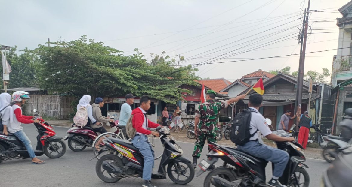 Anggota Koramil 1609 Juntinyuat Indramayu Membantu Masyarakat dan Anak Sekolah Untuk Menyebrang di Jalan Raya Desa Juntinyuat.