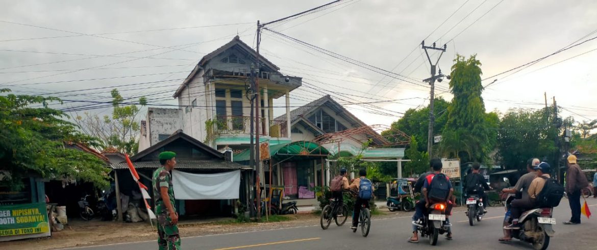 Anggota Koramil 1609 Juntinyuat Indramayu Membantu Masyarakat dan Anak Sekolah Untuk Menyebrang di Jalan Raya Desa Juntikebon.