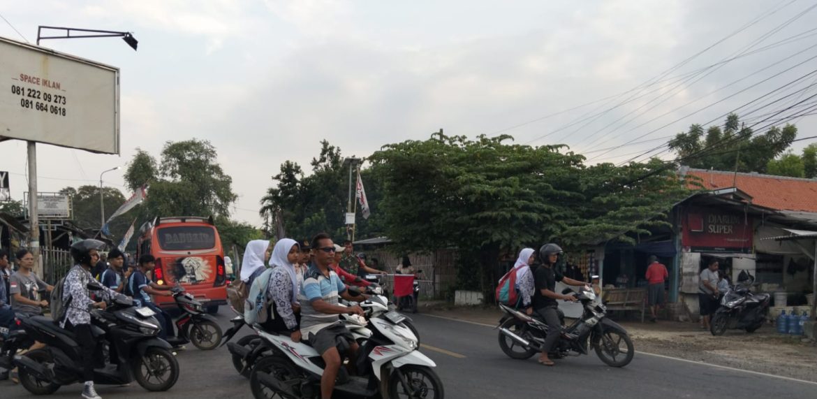 Anggota Koramil 1609 Juntinyuat Indramayu Membantu Masyarakat dan Anak Sekolah Menyebrang Jalan Raya Desa Juntikebon