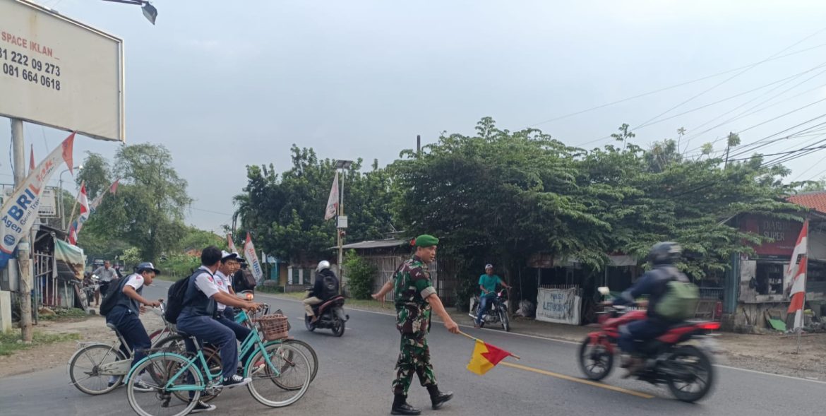 Babinsa Koramil 1609 Juntinyuat Indramayu Bantu masyarakat dan Anak Sekolah Menyebrang Jalan Raya Desa Juntikebon