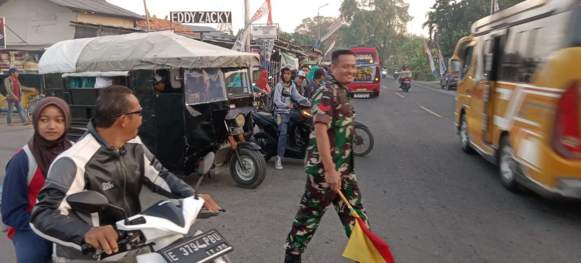 Babinsa Koramil 1609 Juntinyuat Indramayu Bantu Masyarakat dan Anak Sekolah Menyeberang Jalan Raya Desa Juntikebon