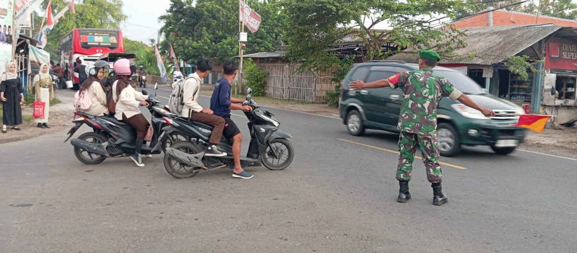 Babinsa Koramil 1609 Juntinyuat Indramayu Bantu Masyarakat dan Anak Sekolah Menyeberang Jalan Raya Desa Juntikebon 