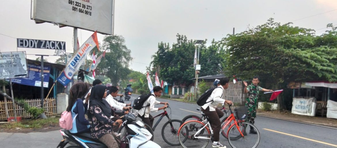 Babinsa Koramil 1609 Juntinyuat Indramayu Bantu Masyarakat dan Anak Sekolah Menyebrang Jalan Raya Desa Juntikebon