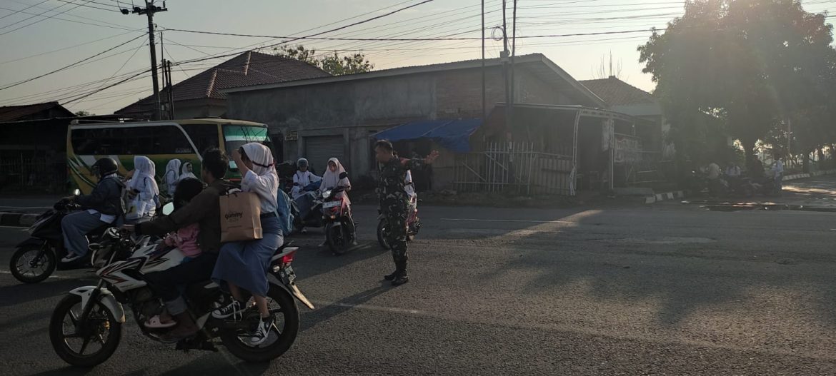 Anggota koramil 1605 Sukagumiwang Bantu Menyeberangkan Anak Sekolah di Jalan By Pass Candangpinggan