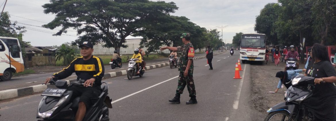 Anggota Koramil 1605 Sukagumiwang Bantu Menyeberangkan Anak Sekolah di Jalan Raya Cadangpinggan