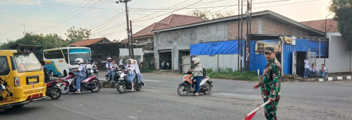 Babinsa Koramil 1605/Sukagumiwang Bantu Penyeberangan Anak Sekolah di By Pass Cadangpinggan