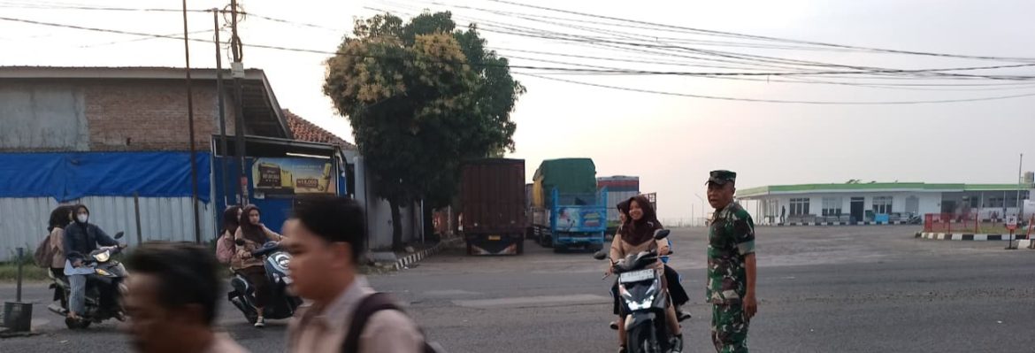 Personel Koramil 1605 Sukagumiwang Bantu Seberangkan Anak Sekolah di Jalan Raya Cadangpinggan