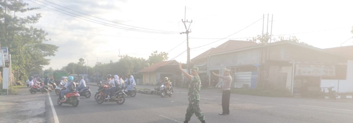 Babinsa Koramil 1605/Sukagumiwang Bersama Polisi Bantu Seberangkan Anak Sekolah di Jalan Raya By Pass Cadangpinggan
