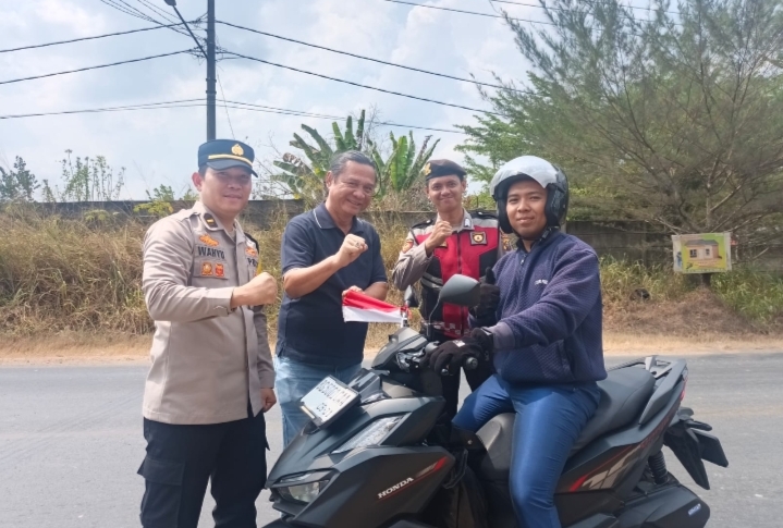 SAMARAKAN HUT RI KE-81, POLRES OGAN ILIR PASANGKAN BENDERA MERAH PUTIH KE KENDARAAN WARGA